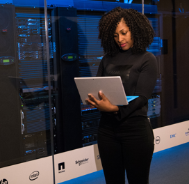 Woman with computer in server room