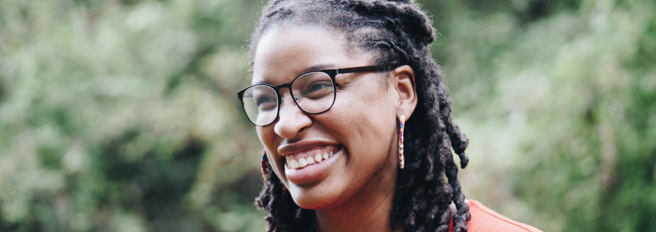 A young woman with glasses smiling