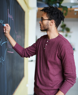 Undergraduate student writing on board