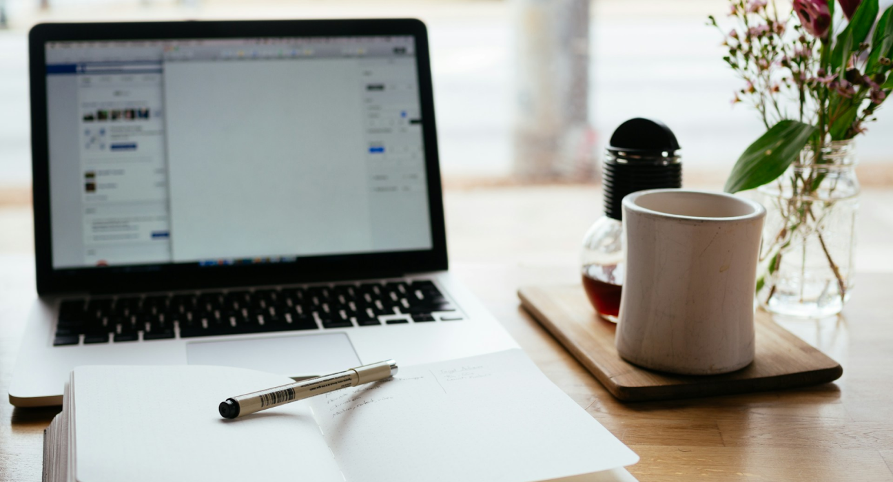 Laptop computer with notebook and cup of coffee