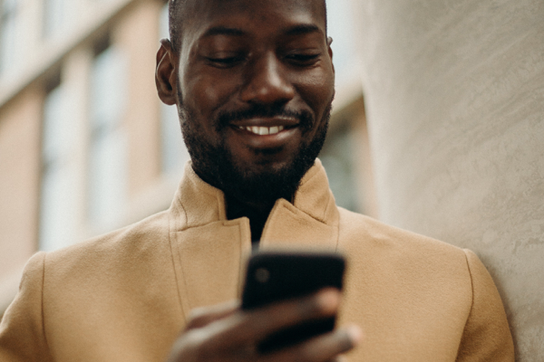 Man using phone to check Alumni Member benefits