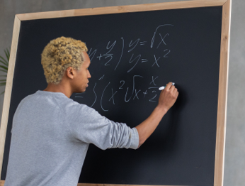 Teacher at blackboard doing math equation