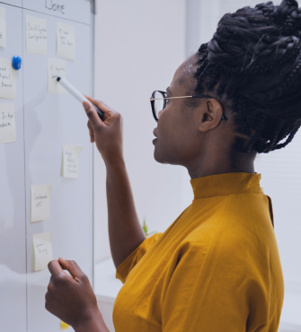 Female student at whiteboard with post-it notes