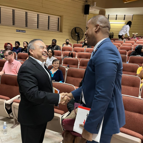 OAS Ambassador Nestor Mendez and Grace Foods CEO Frank James shaking hands and sharing a laugh