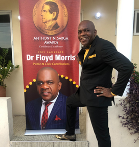  Senator Dr Floyd Morris posing by the Sabga Banner